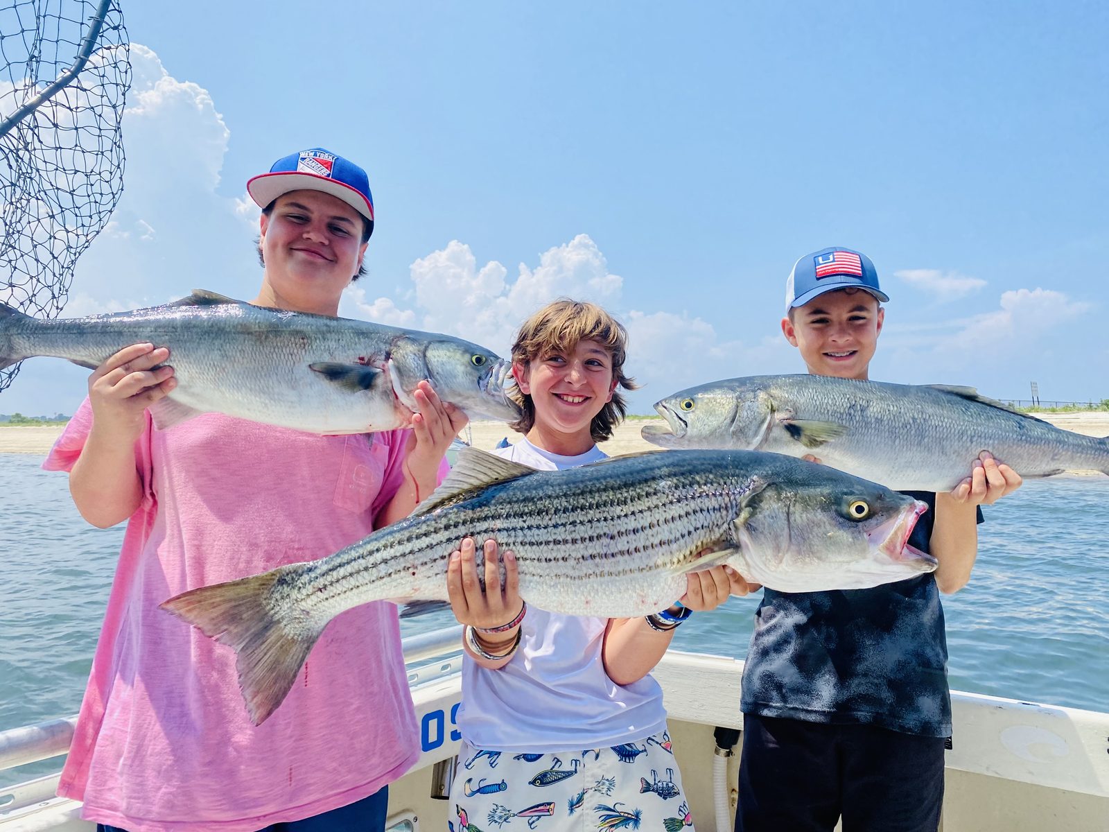 Three kids with striped bass and bluefish
