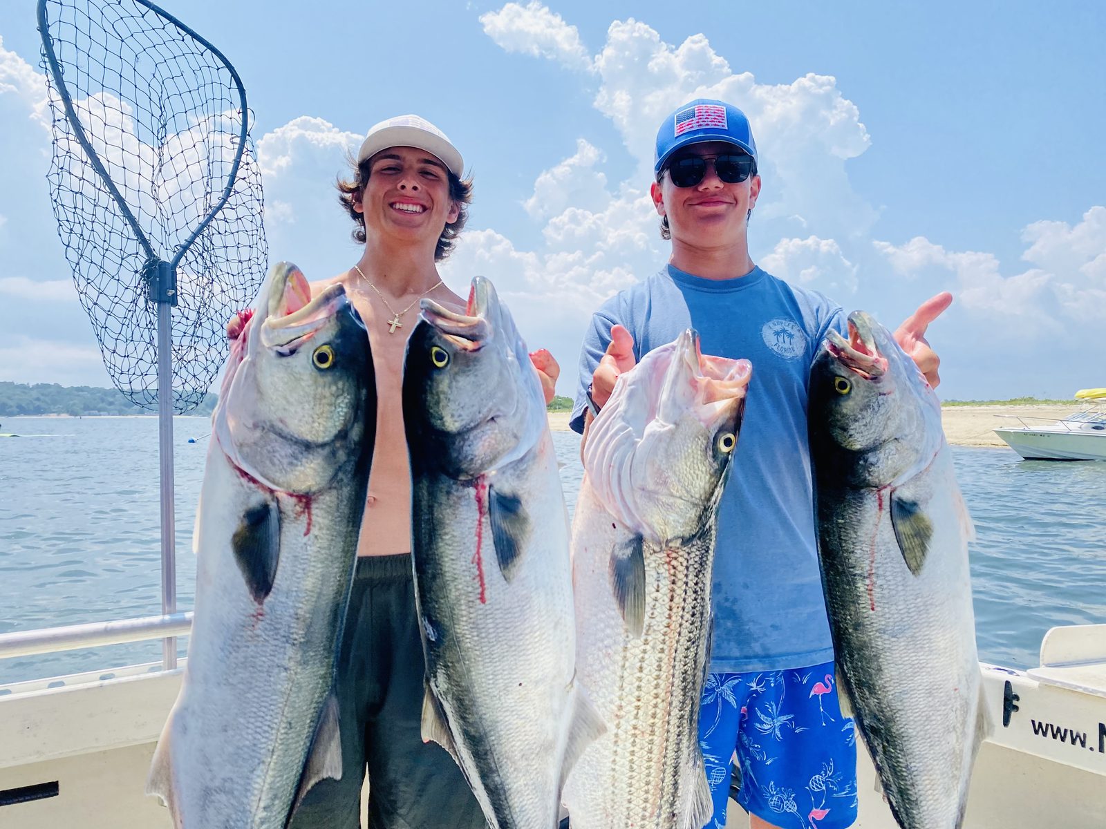 Two young anglers with striped bass and bluefish