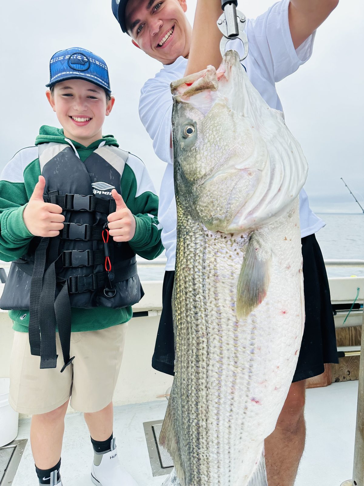 A camper with a 36-pound striped bass, the largest ever caught at the kids camp
