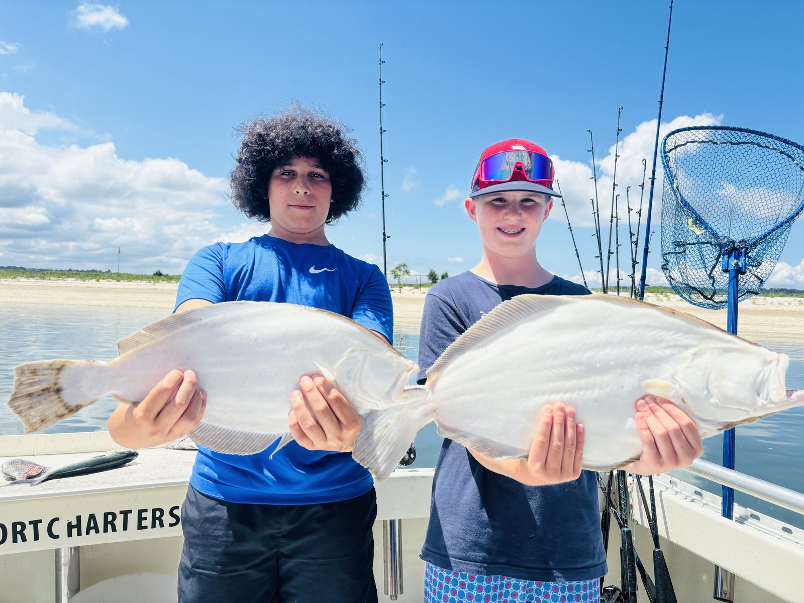 Two young anglers, each with a fluke