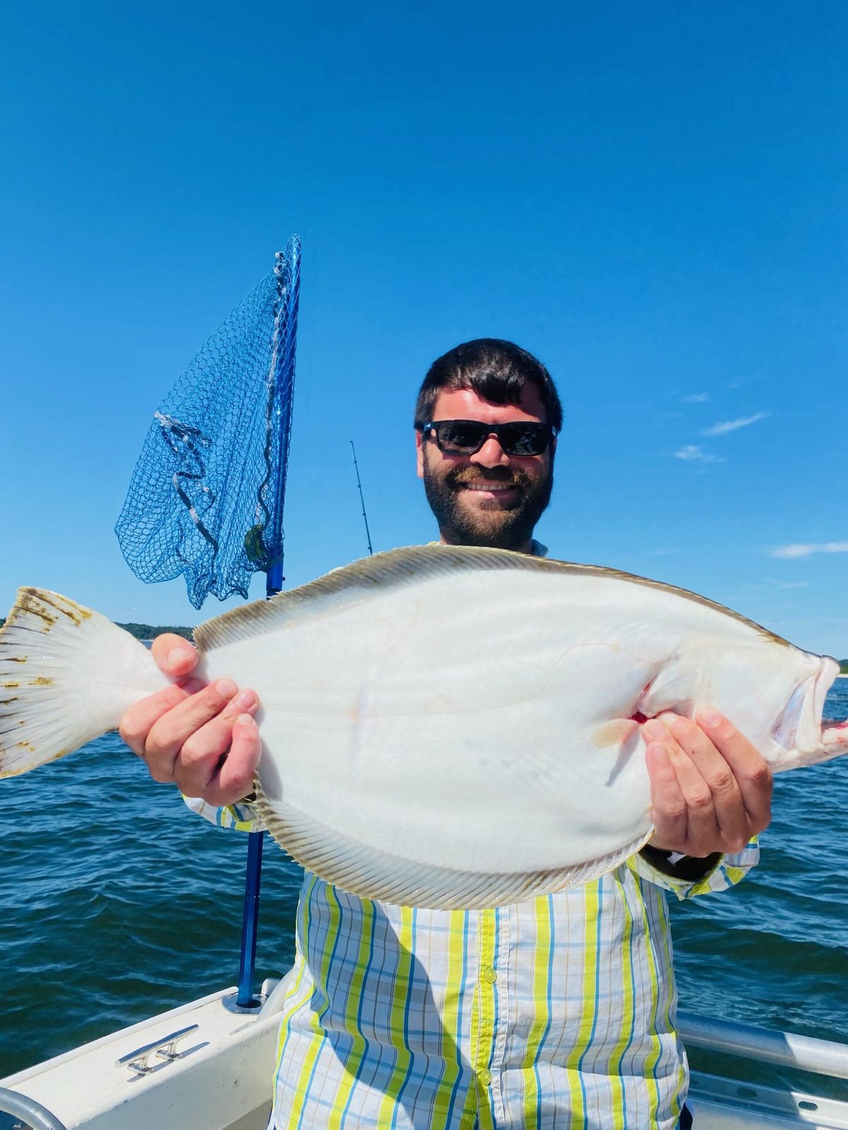 Angler holding a fluke at the rail