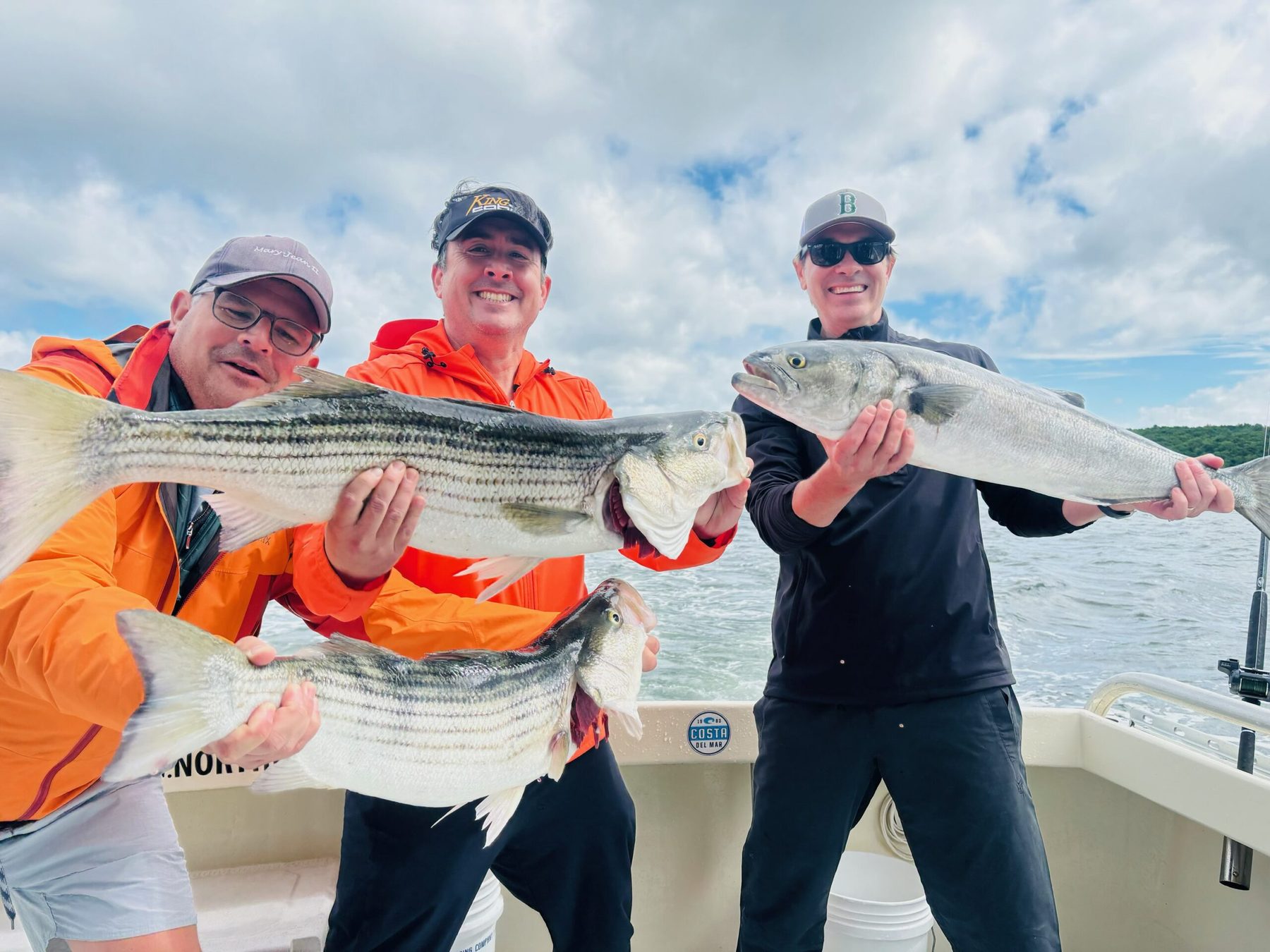 Charter party holding a striped bass aboard Sashimi