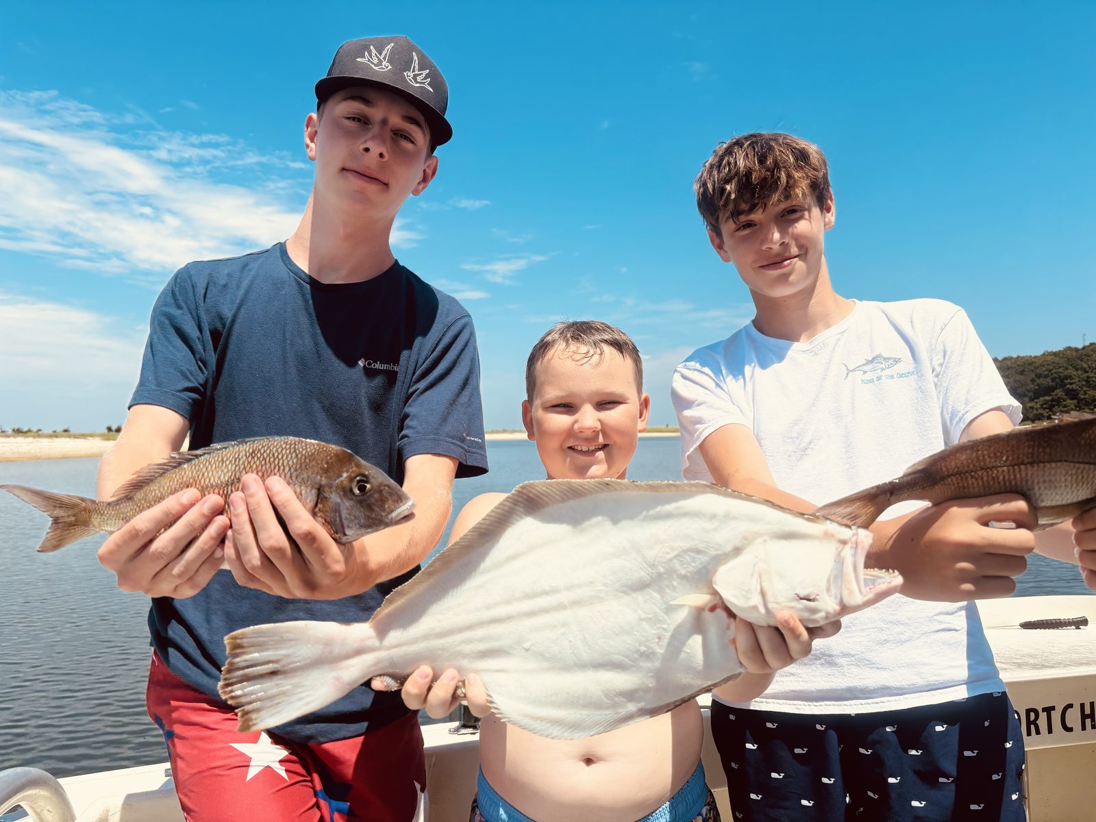 Three kids with a fluke and porgies