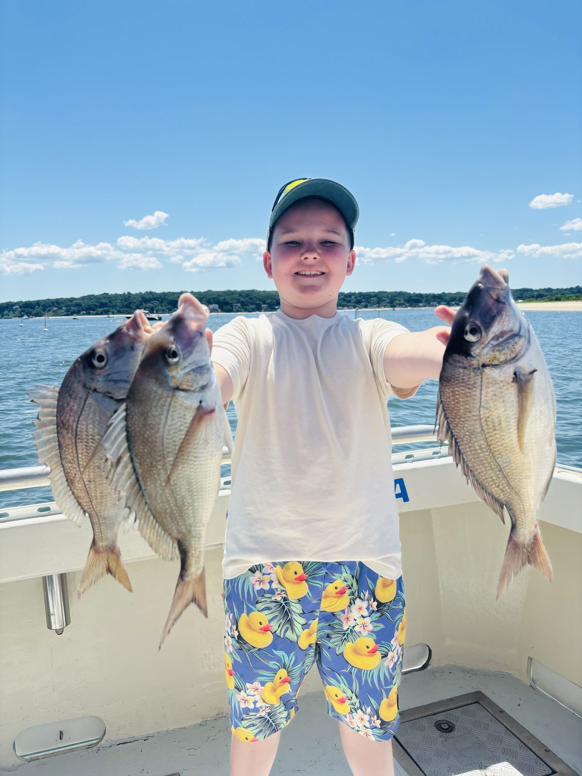 A young angler with three porgies