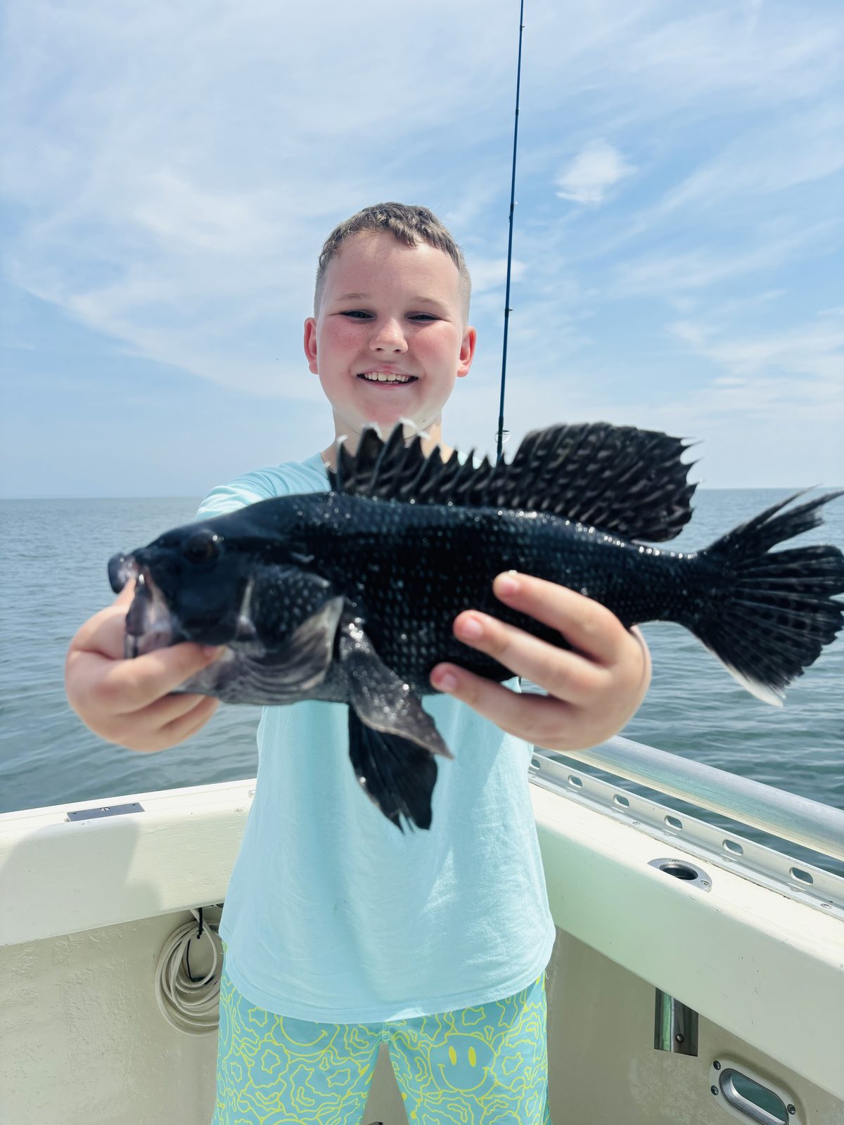 A young angler with a black sea bass