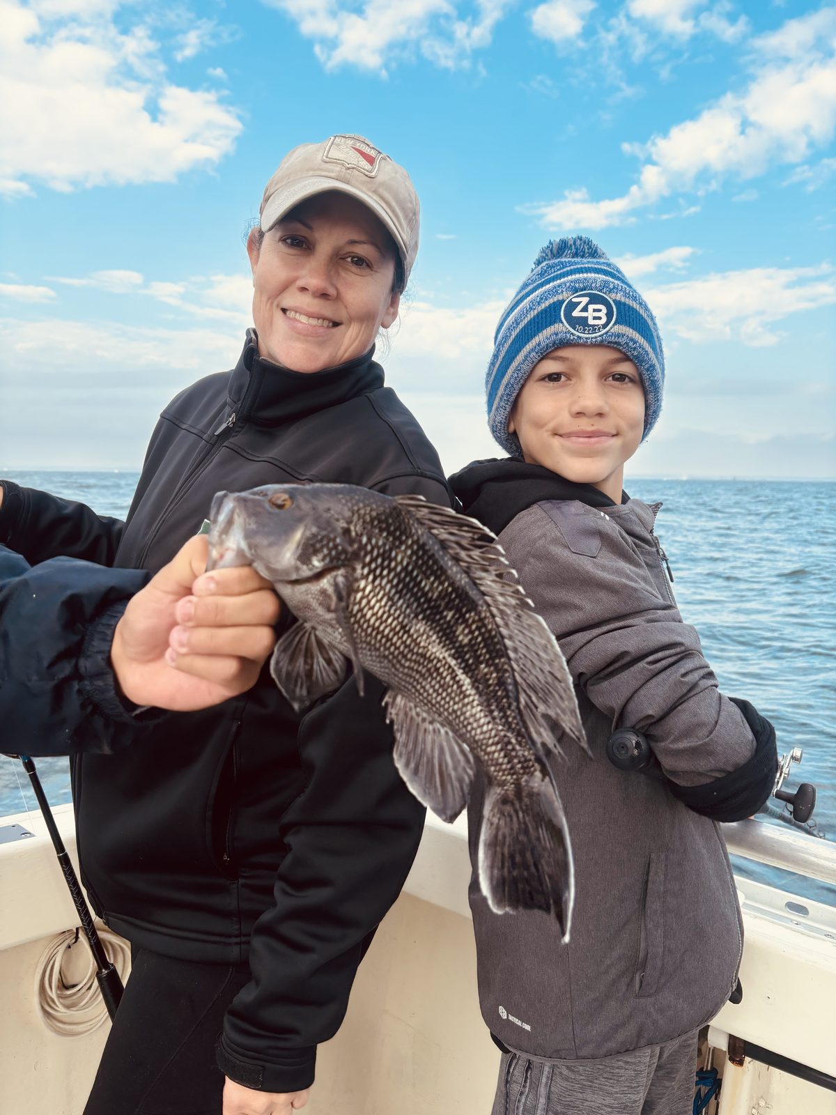 An angler and a boy with a black sea bass