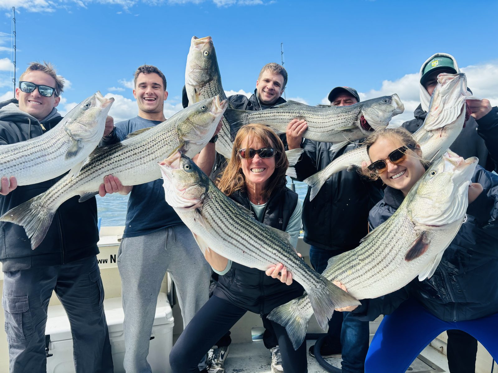 A charter group holding up their striped bass
