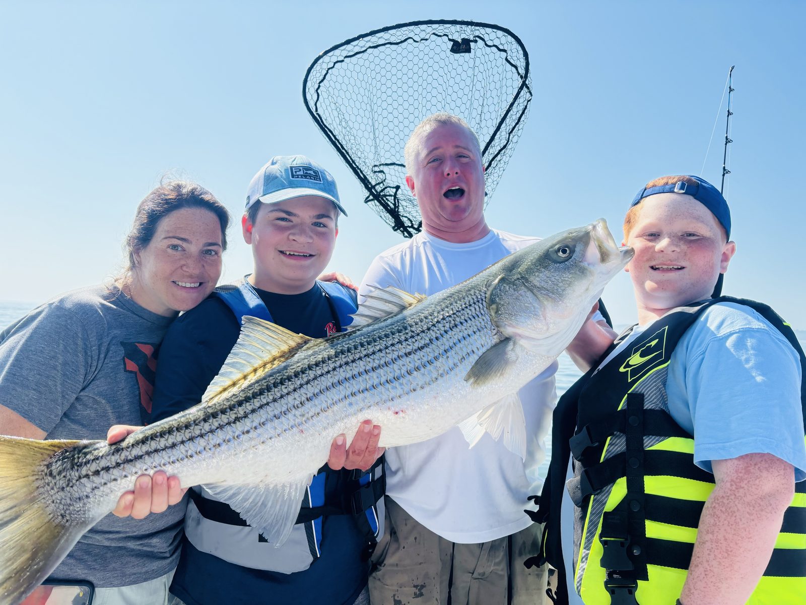 A family with a big striped bass
