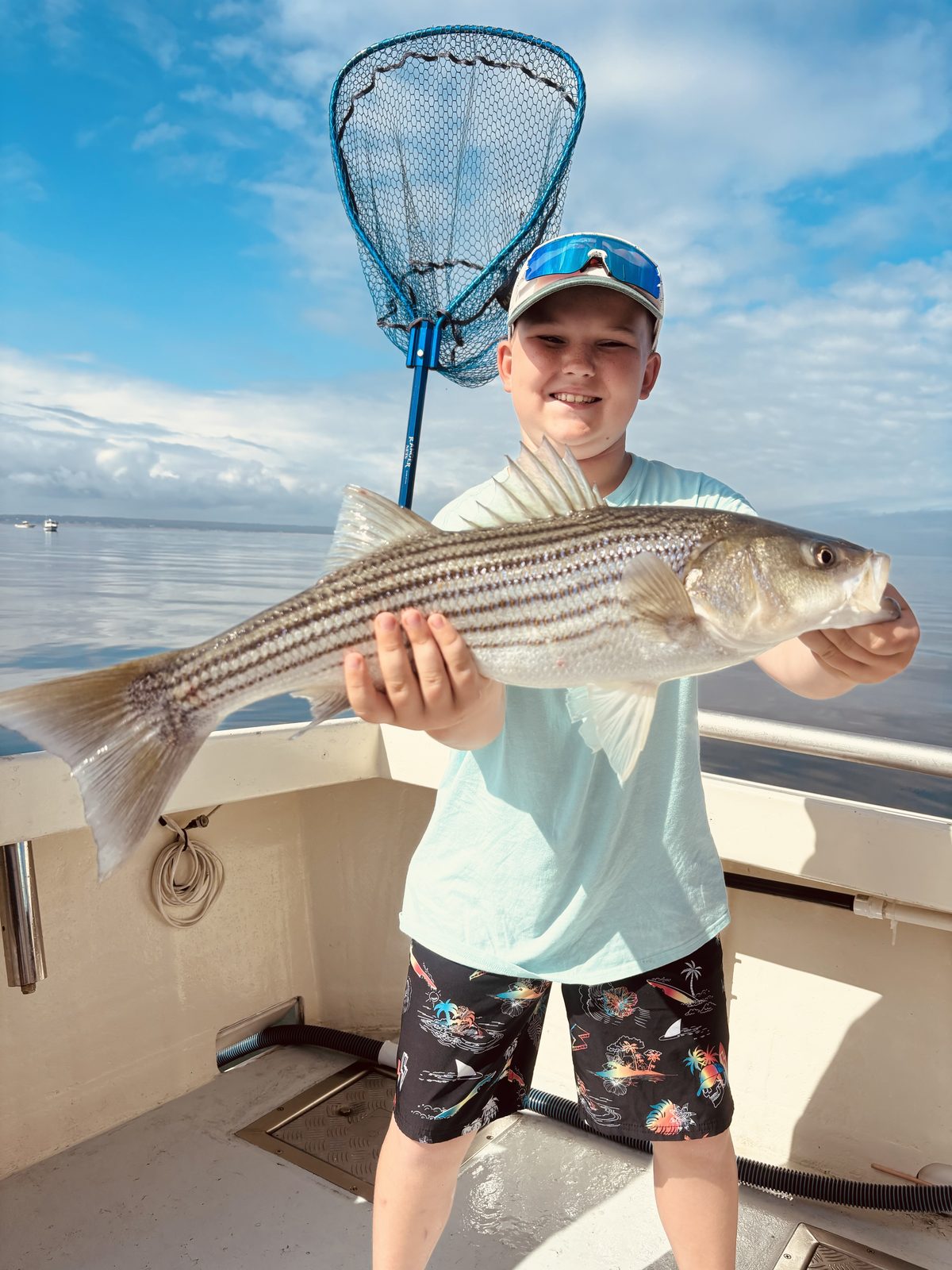 A young angler with a striped bass
