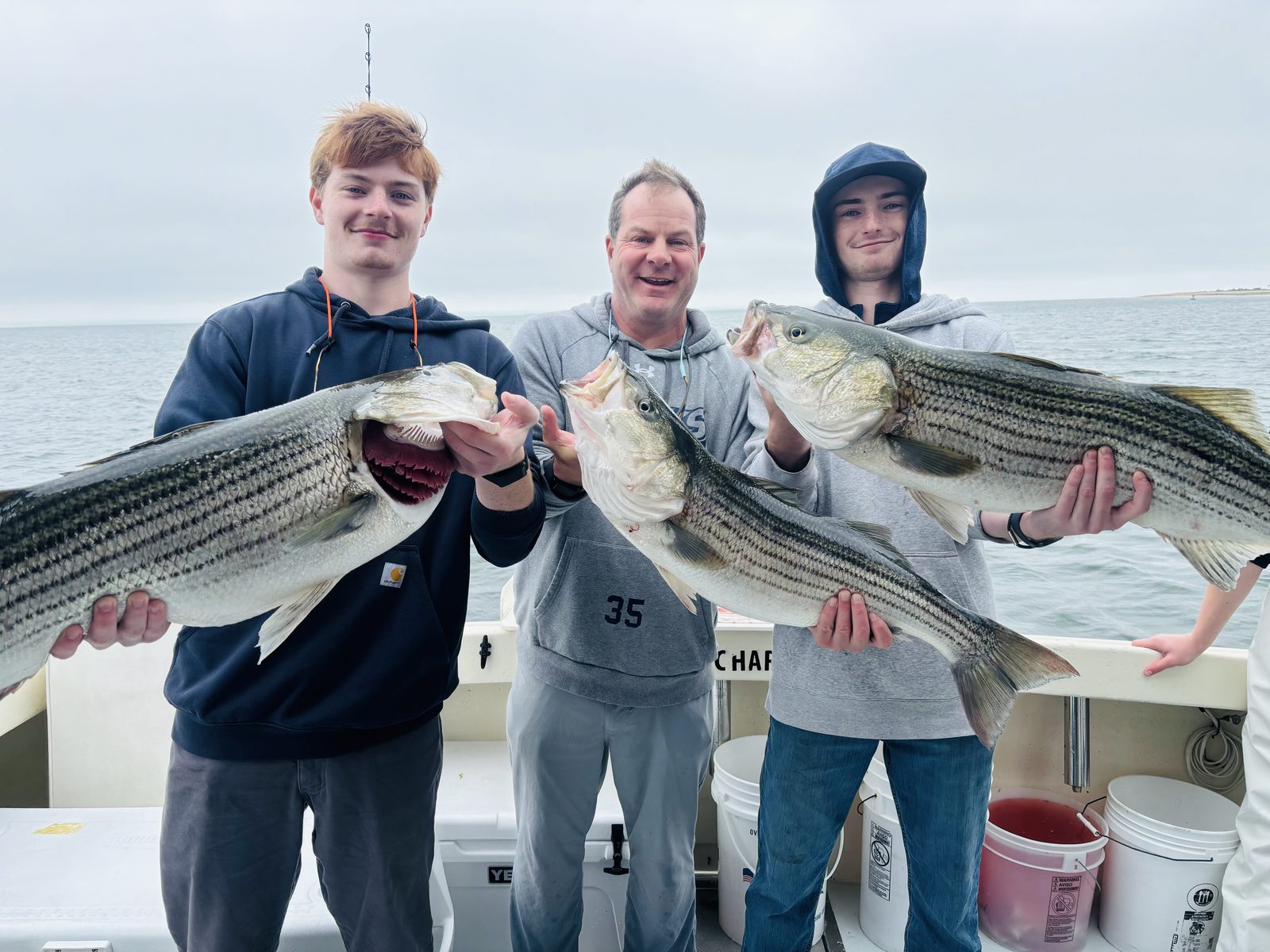 Three anglers with striped bass